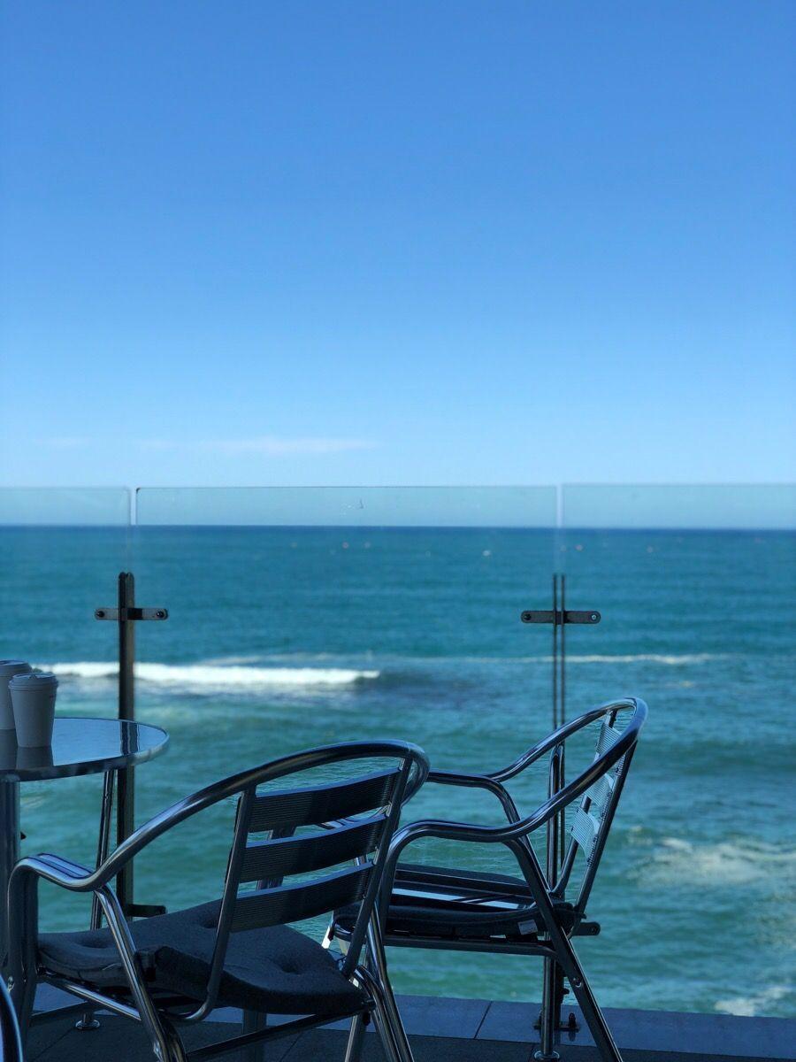 Anchor Coffee的露臺，座椅面向大海，享受海景的放鬆場景。